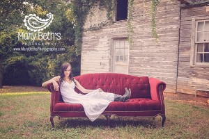 Senior Portrait in outdoor setting on a red couch