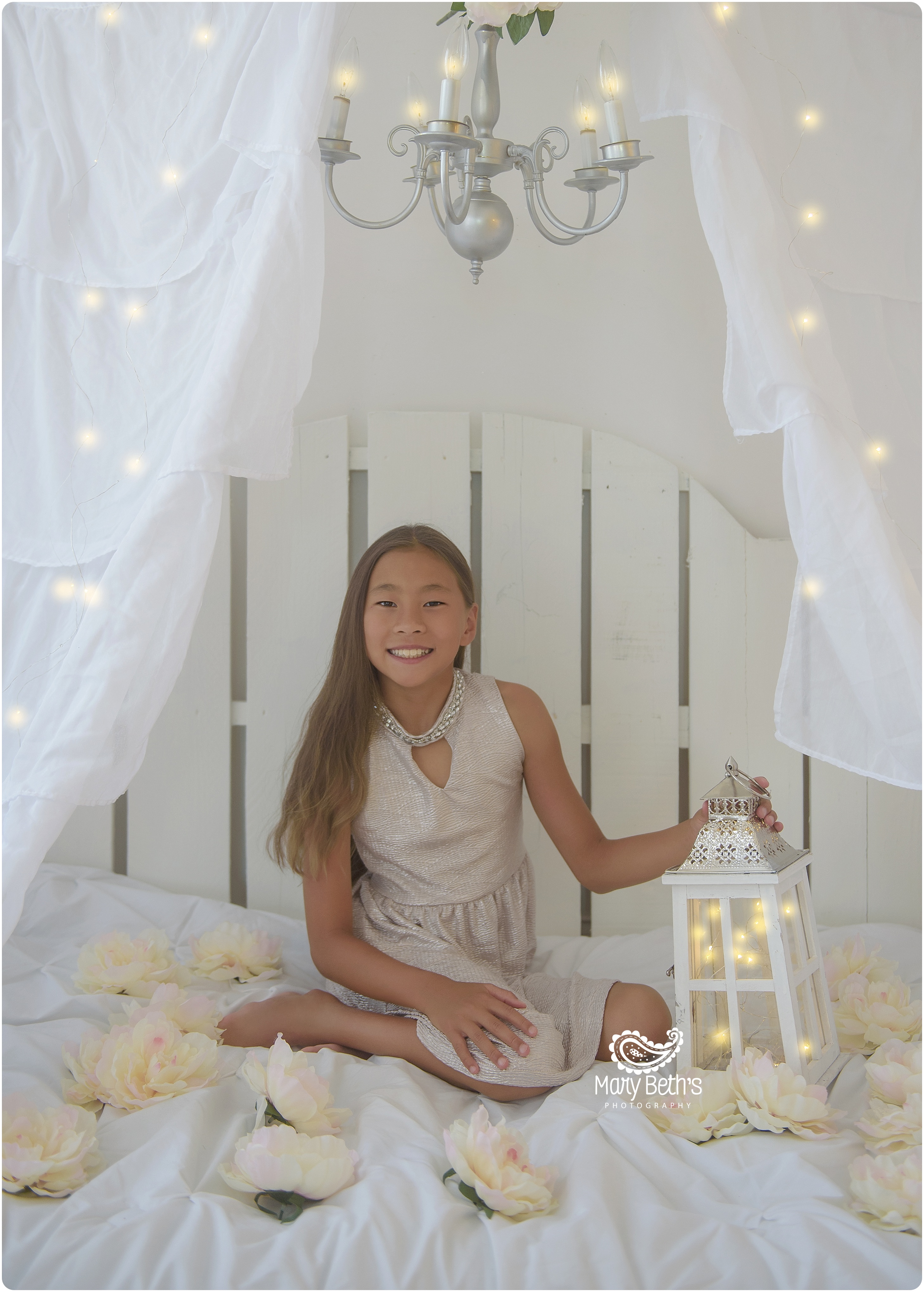 Girl in fairylight tent with lantern and hanging tulips
